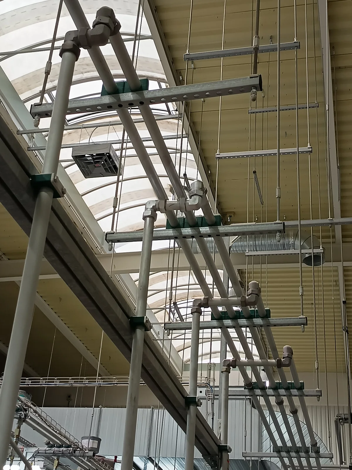 Overhead pipework and supports for ink distribution.
